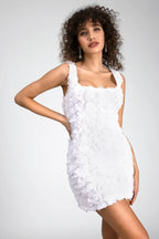 Woman in a white floral mini dress with a square neckline