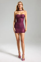 Full-body view of a woman in a purple rhinestone mini dress and high heels.