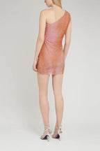 Back view of a woman in a shimmering one-shoulder mini dress with ruching and asymmetrical hem.