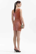Back view of a woman in a shimmering one-shoulder mini dress with ruching and asymmetrical hem, wearing heeled mules.