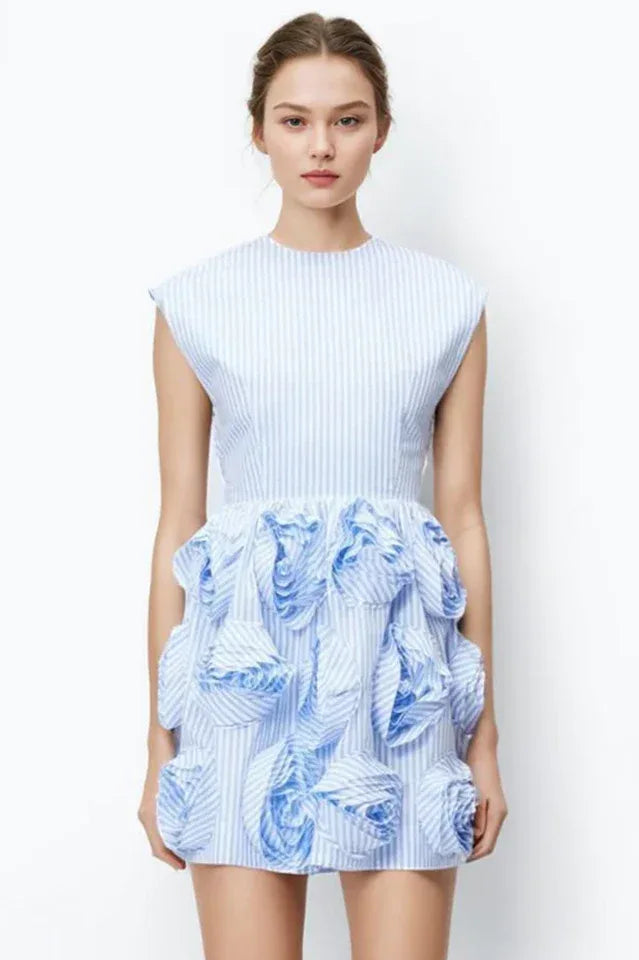 Woman wearing a blue and white striped mini dress with floral embellishments on the skirt.