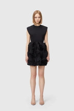 Full body shot of a woman in a black mini dress with floral embellishments.
