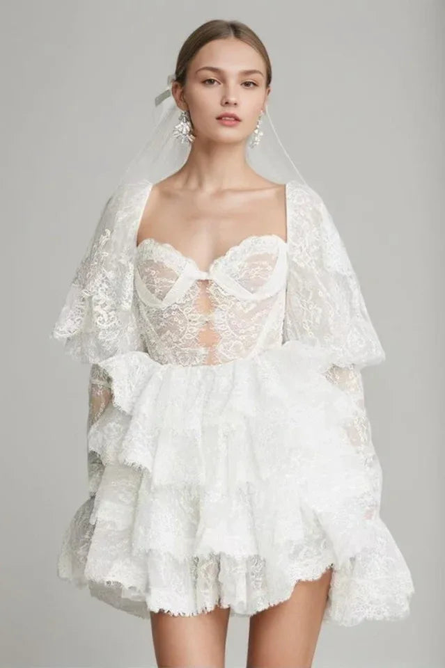 Woman wearing a white mini dress with a ruffled neckline and tiered skirt.