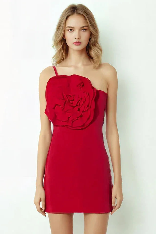 Woman wearing a red one-shoulder sheath dress with a large floral applique on the bust