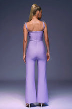 Back view of a woman in a lavender wide-leg jumpsuit with a zipper closure