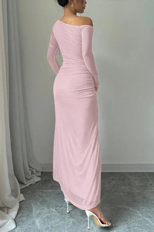 Rear view of a woman in a pink one-shoulder ruched maxi dress, showcasing the flowing silhouette.