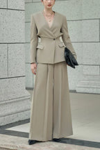 Woman wearing a beige tailored suit with wide-leg pants and a V-neck blazer.