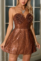 Woman wearing a brown sequined mini dress with floral applique bodice and spaghetti straps.