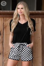 Woman wearing black t-shirt and black and white checkered athletic shorts