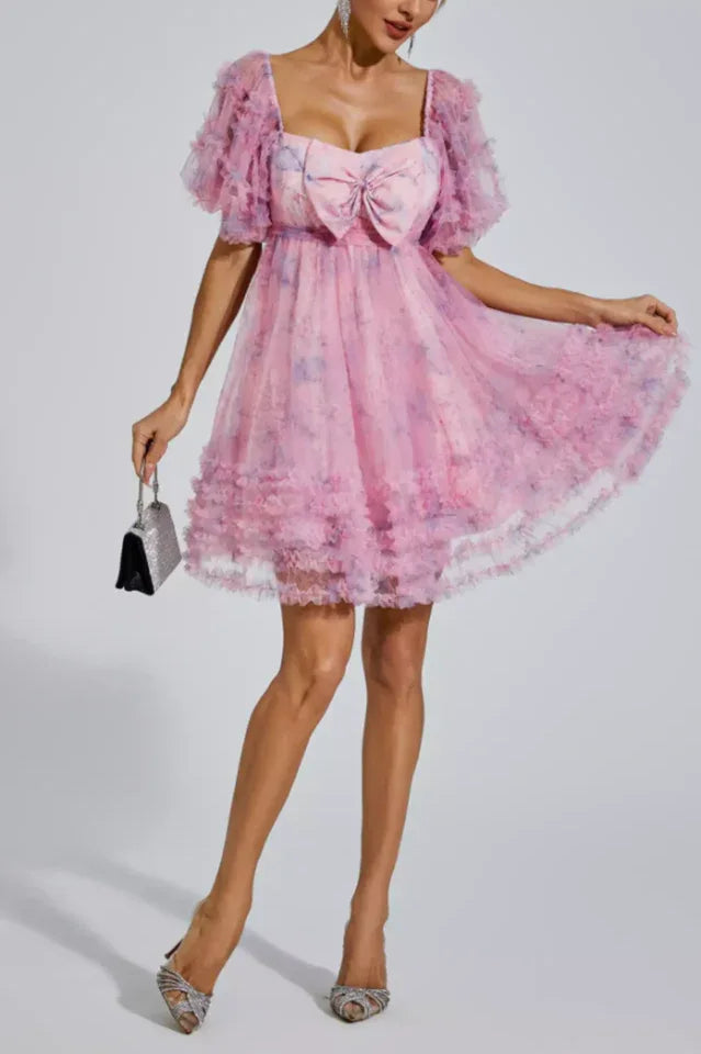 Full length view of a woman in a pink floral print tulle dress with ruffled elements