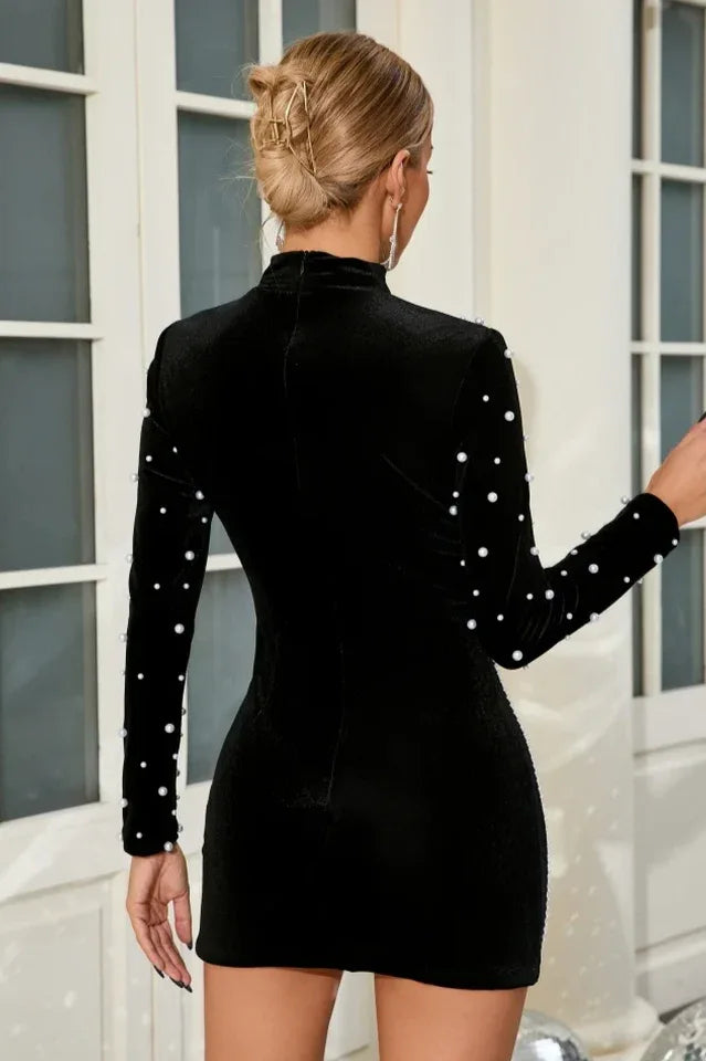 Close-up of beadwork on the shoulders and sleeves of a black dress