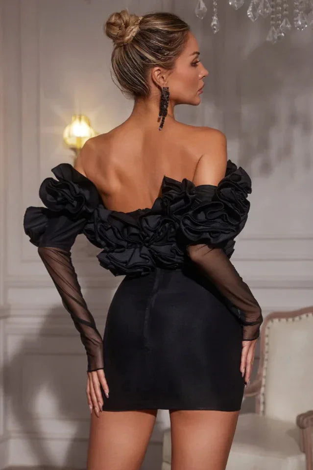 Back view of a black off-the-shoulder mini dress with ruffled detail and sheer sleeves