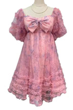 Mannequin displaying a pink floral print tulle dress with a bow and ruffled details