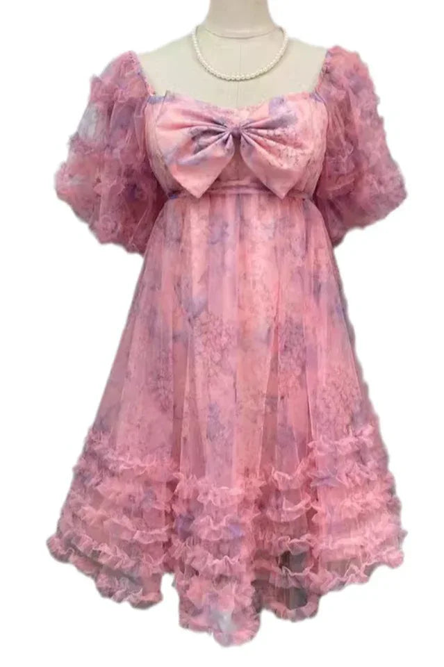 Mannequin displaying a pink floral print tulle dress with a bow and ruffled details