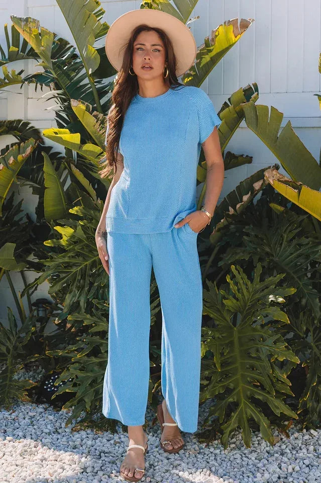 Woman wearing a blue ribbed knit short sleeve top and matching wide leg pants