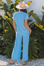 Back view of a woman in a blue ribbed knit top and wide leg pants