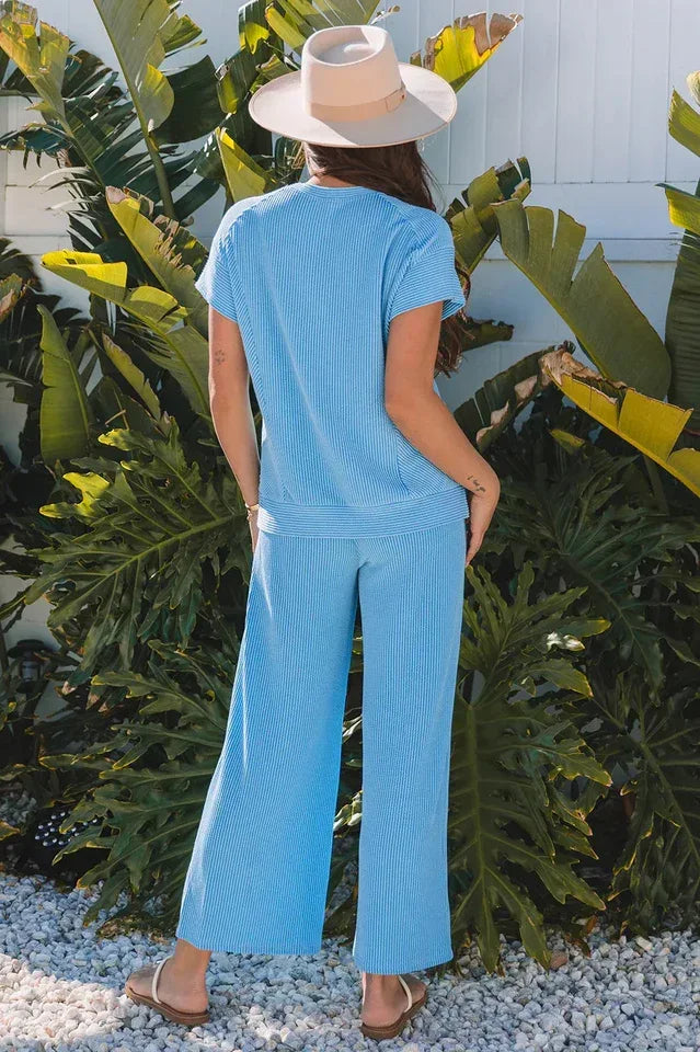 Back view of a woman in a blue ribbed knit top and wide leg pants