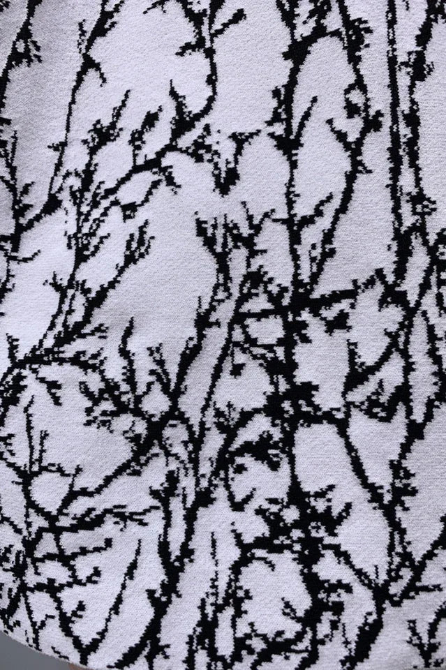 Close-up of the black branch print on a white textured fabric