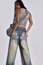 Woman in motion wearing wide leg light wash denim jeans and a cropped tank top