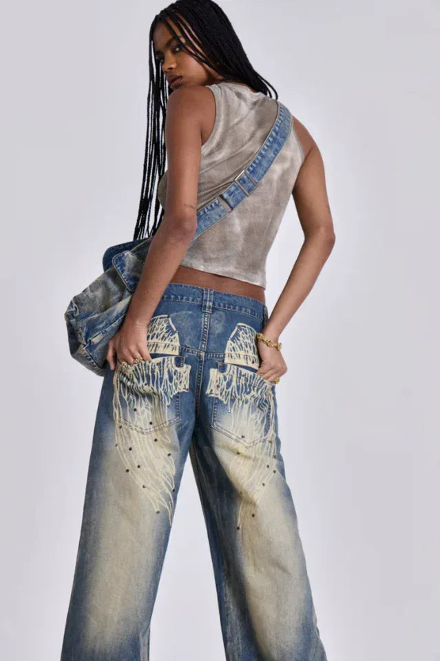 Woman in motion wearing wide leg light wash denim jeans and a cropped tank top