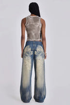 Woman standing with hands in pockets of wide leg light wash denim jeans