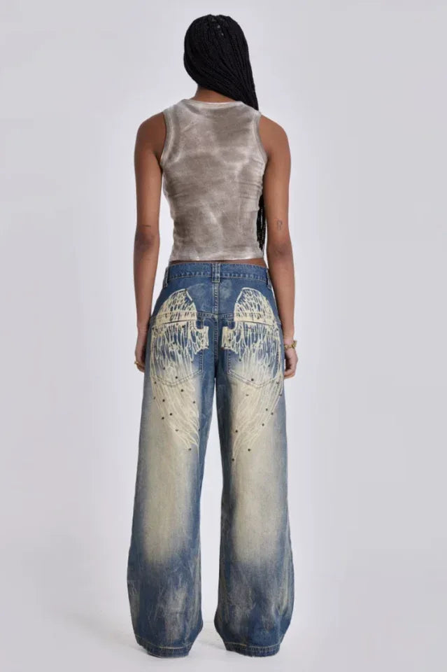 Woman standing with hands in pockets of wide leg light wash denim jeans