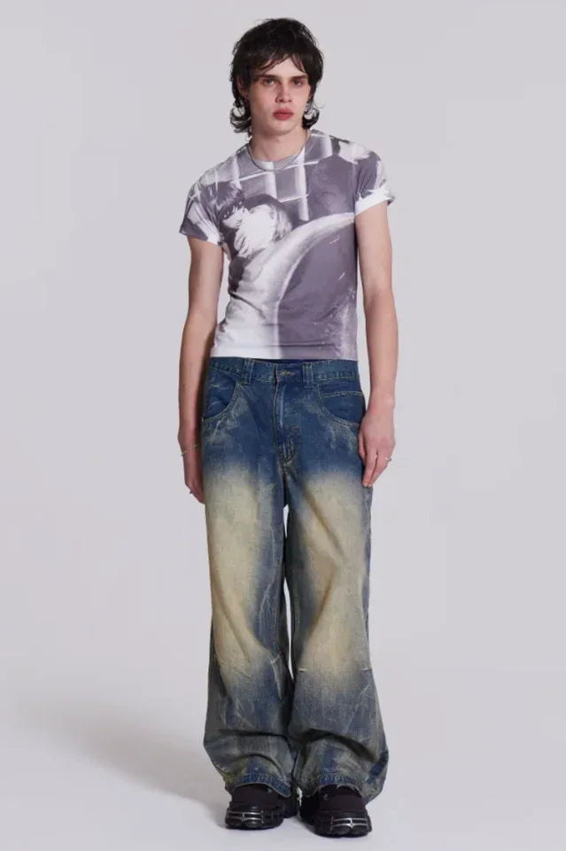 Model posing with arms crossed, showcasing the fit and detail of wide leg light wash denim jeans