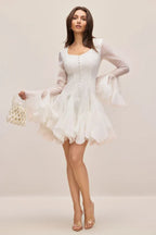 Full body shot of a woman in an elegant white dress with voluminous sleeves.