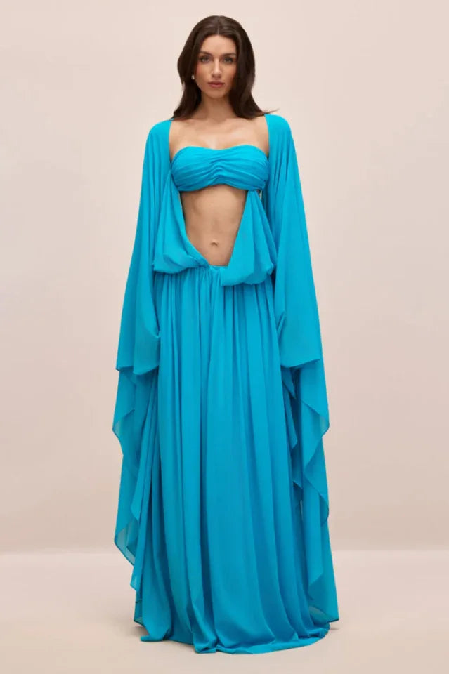 Woman wearing a blue asymmetric draped maxi dress with cape sleeves Main image