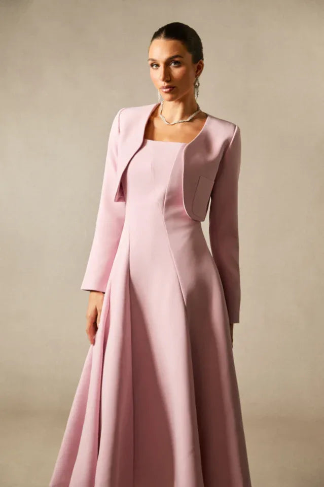 Close-up of the bodice and jacket of a pink formal dress, highlighting the square neckline and tailored jacket details.