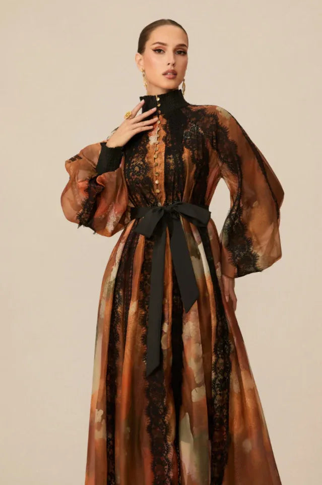 Close-up of the upper body of a woman in a high-neck printed dress with button details and lace.