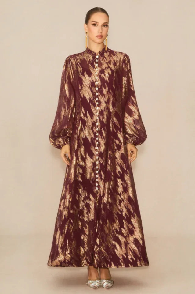 Full-length view of a burgundy and gold abstract print maxi dress with a button-down front