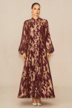 Full-length view of a burgundy and gold abstract print maxi dress with a button-down front