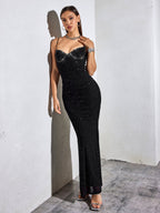 Woman wearing a black glittery floor-length mermaid dress with spaghetti straps