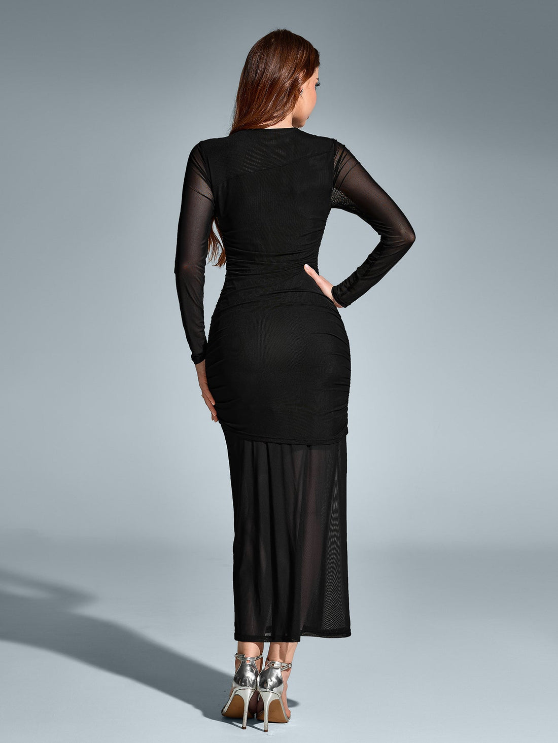 Woman in a black long-sleeve ruched mesh maxi dress