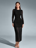 Full-length view of a woman in a black ruched mesh maxi dress