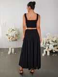 Back view of a woman in a black smocked crop top and maxi skirt