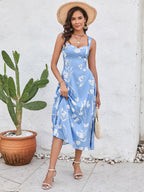 Woman lifting the hem of a blue floral print midi dress, showcasing the midi length.
