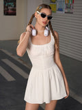 Woman wearing a white sleeveless mini dress with sunglasses and headphones