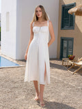 Woman wearing a white midi dress with spaghetti straps and a thigh-high slit