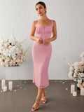Woman posing in a pink crepe midi dress with ruched bodice and lace detail