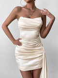 Close-up of the bodice of a cream strapless ruched satin mini dress with a draped asymmetrical train