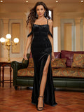 Woman in a black velvet evening gown with a high slit and off-the-shoulder sleeves