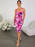 Full body shot of a woman in a ruched abstract floral print dress and high heel sandals.