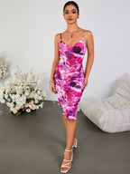 Full body shot of a woman in a ruched abstract floral print dress and high heel sandals.