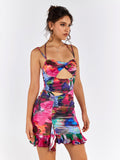 Side profile of a woman wearing a colorful abstract floral print bodycon mini dress with ruching and a cut-out.