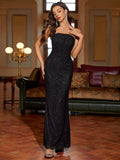 Woman posing in a black strapless sequined mermaid evening gown, front view with hand on chest