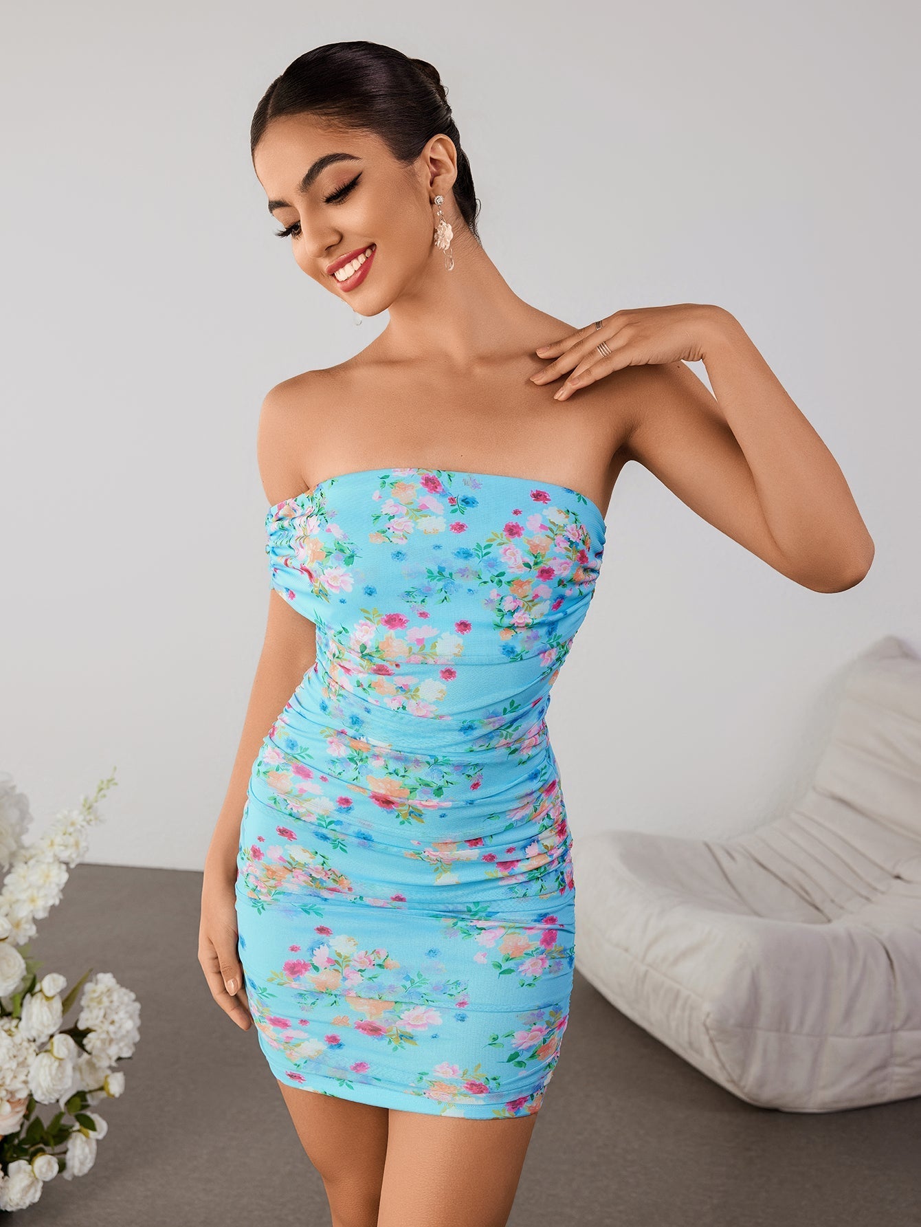 Woman wearing a blue floral off-the-shoulder ruched mini dress, strapless front view