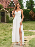 A woman in a white elegant maxi dress with spaghetti straps and a thigh-high slit, touching her hair.