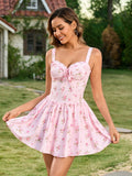 Close-up of a woman in a pink floral print mini dress with tie front detail, outdoors